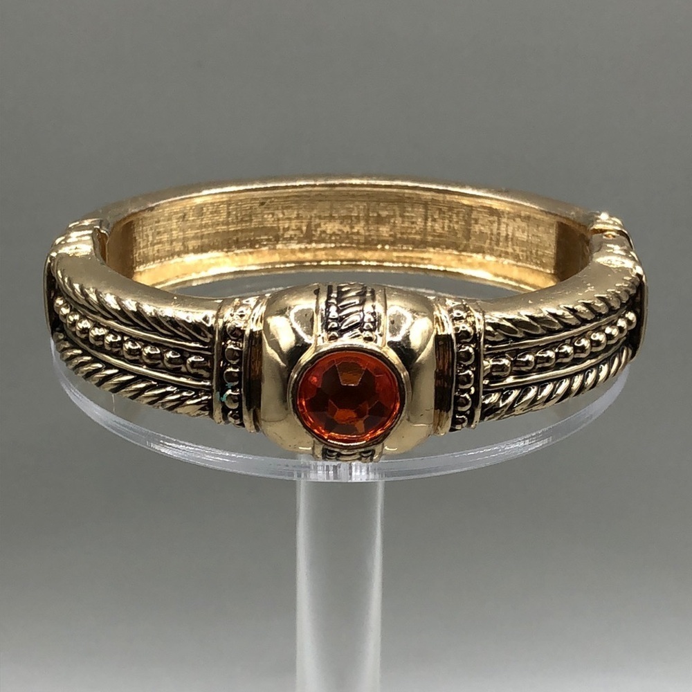Vintage gold tone dressy statement hinge clamper bracelet with faux gemstone.